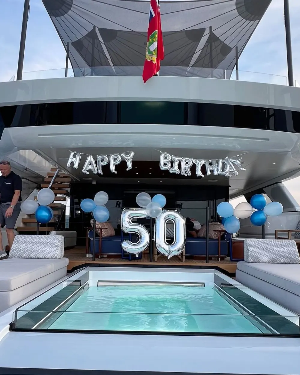 A celebration cake and decorations set up on a yacht deck